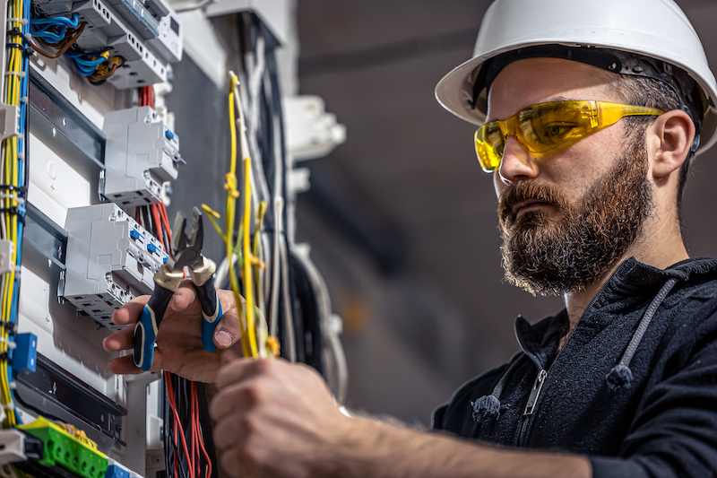 Profissional que possui curso técnico de eletroeletrônica fazendo manutenção em caixa de energia
